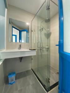 a bathroom with a glass shower and a sink at Alicia Hotel in Tuy Hoa