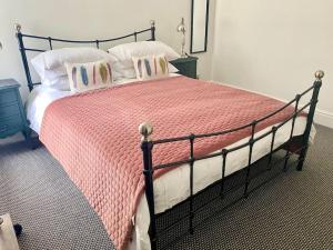 a bedroom with a large bed with a pink blanket at Lovely 2 bedroom apartment in Much Wenlock in Much Wenlock