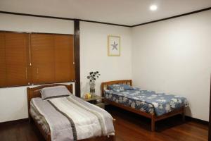 a bedroom with two twin beds and a table at Private Tropical 3 Bedroom Villa - Nongsa Village Batam in Telukmataikan +18 photos