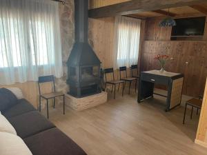 sala de estar con fogones, mesa y sillas en Casa Rural Riópar, luxury in nature en Riópar