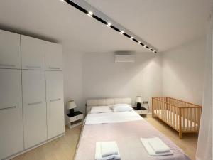 a bedroom with a large bed and white cabinets at Apartment Sand Lilies in Sozopol