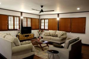 a living room with two couches and a tv at Private Tropical 3 Bedroom Villa - Nongsa Village Batam in Telukmataikan