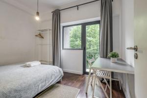 - une chambre avec un lit, un bureau et une fenêtre dans l'établissement Travel and Live Apartments, à Porto