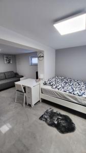 ein Schlafzimmer mit einem Bett, einem Schreibtisch und einem Sofa in der Unterkunft Apartma ALTER EGO in Koper