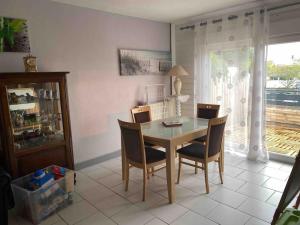 a dining room with a table and chairs at Loue maison quartier calme in Royan