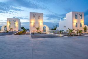 ティガキにあるXenos Villa 7 with a Private pool near the seaの夜間の駐車場内にある白い建物2棟