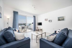 a living room with two blue couches and a table at Xenos Villa 7 with a Private pool near the sea in Tigaki