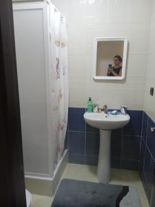 a person taking a picture of a bathroom with a sink and shower at Zenhouse in Asilah