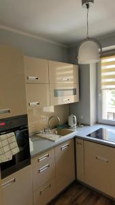 uma cozinha com armários brancos e um lavatório em Apartament em Nakło nad Notecia