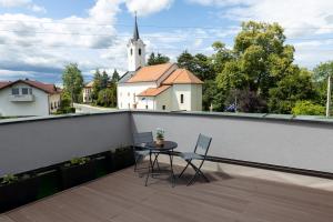 un balcone con tavolo, sedie e chiesa di Apartma PUHAN 