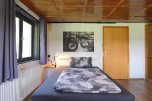 a bed in a room with a motorcycle on the wall at Hus8 Krumbach in Krumbach