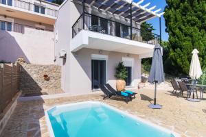 a villa with a swimming pool and a house at Noir Luxury Suite by CorfuEscapes in Corfu
