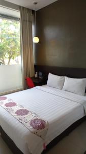 TemulusにあるCendana CoLiving Solo Baruのベッドルーム(大きな白いベッド1台、窓付)