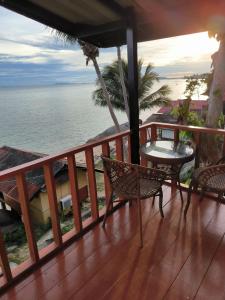 balcón con mesa, sillas y vistas al océano en Golden Beach Resort Koh Phangan, en Baan Tai