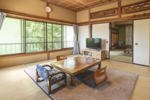 een woonkamer met een houten tafel en stoelen bij AI/藍 in Kusatsu