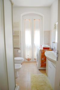 uma casa de banho branca com um WC e um lavatório em La Piazza - appartamento em Piana Battolla