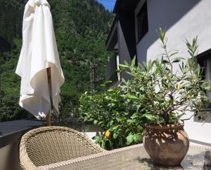 een rieten stoel en een witte parasol op een patio bij monas home mayrhofen in Mayrhofen