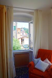 uma sala de estar com uma grande janela e um sofá em La Piazza - appartamento em Piana Battolla
