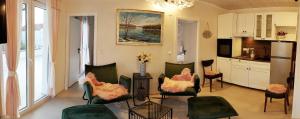 a living room with chairs and a table and a kitchen at Luxury Apartment Slavica in Vodice