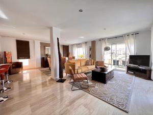 ein Wohnzimmer mit einem Sofa und einem TV in der Unterkunft Penthouse - residence La Mina - Albir avec WIFI GRATUIT in Albir
