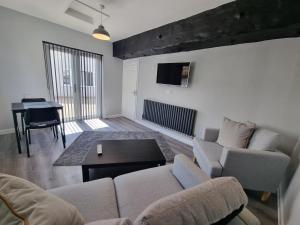 a living room with a couch and a table at The Forge by Cliftonvalley Apartments in Bristol