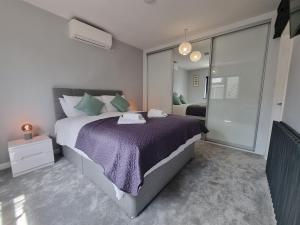 1 dormitorio con 1 cama grande con manta morada en The Forge by Cliftonvalley Apartments, en Bristol