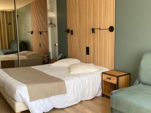 a bedroom with a large bed and a mirror at Les Alcyons in Le Lavandou