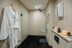 La salle de bains est pourvue d'une douche et d'un peignoir blanc. dans l'établissement La Casa 113, Sanctuaire de Luxe, à Casablanca
