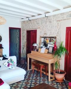 uma sala de estar com um piano e um sofá em Grande maison coeur de village piscine jacuzzi em Maureillas