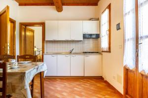 a kitchen with white cabinets and a table at Margherita - Agriturismo La Fattoria in Grosseto +16 photos