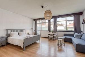una camera con letto, divano e tavolo di Travel & Live Aliados Apartment a Porto