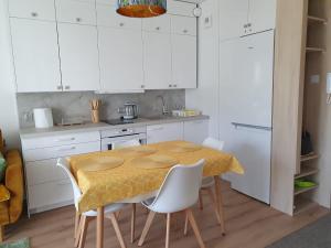 kuchnia z drewnianym stołem i białymi szafkami w obiekcie Apartament Comfort Del Mar V w Kołobrzegu