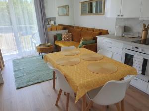 kuchnia i salon ze stołem i krzesłami w obiekcie Apartament Comfort Del Mar V w Kołobrzegu