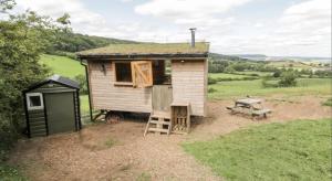 a tiny house with a ladder and a bench at Shepherds Hut by Stepney Stays in Scarborough