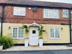 a yellow brick house with a white door at 2 Bed Cosy Cottage - Central Bawtry - High End Furnishings in Bawtry