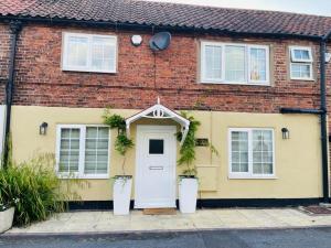 a yellow brick house with a white door at Cosy Cottage - Church St, Bawtry - Entire Cottage in Bawtry