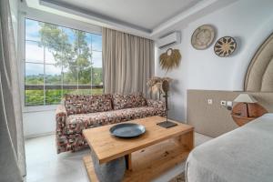 a living room with a couch and a table at Arco Beach Hotel in Agia Paraskevi