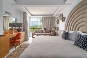 - une chambre avec un lit, un bureau et un canapé dans l'établissement Arco Beach Hotel, à Agia Paraskevi