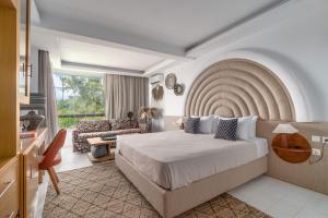 une chambre d'hôtel avec un lit et un canapé dans l'établissement Arco Beach Hotel, à Agia Paraskevi