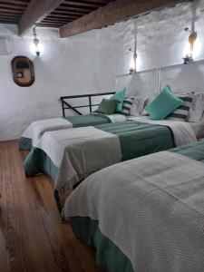 een slaapkamer met twee bedden met groene kussens erop bij Casa Centrica con garage in Mercedes