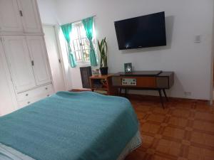 een slaapkamer met een bed en een tv aan de muur bij Casa Centrica con garage in Mercedes