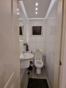 a white bathroom with a sink and a toilet at SAKN 3 - Two Bedroom Apartment in Amman