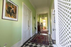 a hallway with green walls and a painting on the wall at Le Jardin Umal in Montendre