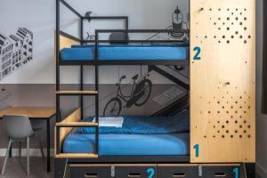 ein Zimmer mit zwei Etagenbetten und einem Schreibtisch in der Unterkunft Stayokay Hostel Amsterdam Oost in Amsterdam