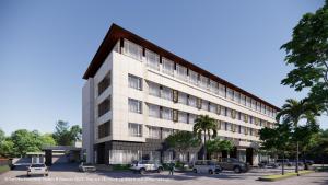 a large white building with cars parked in a parking lot at Hotel Santika Lahat in Lahat