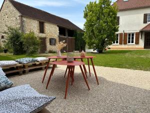 La Gravonne, une parenthèse turroise في Turny: طاولة عليها مزهريات في ساحة