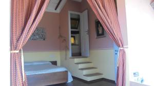 セッジャーノにあるLa casina di Giannettoのベッドルーム1室(階段付)、ベッド1台(カーテン付)