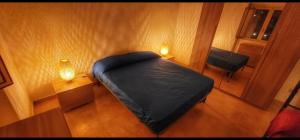 Un pequeño dormitorio con una cama negra y una silla en Casa Cilento nel Verde, en Rutino