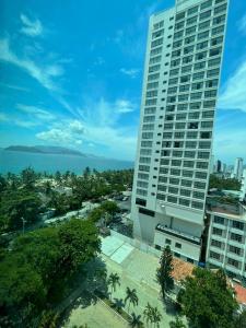 a tall building with the ocean in the background at Ngoc Khanh hotel in Nha Trang