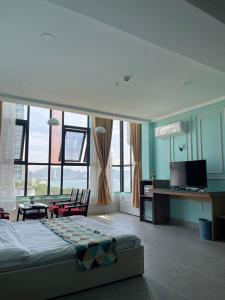 Dormitorio con cama, escritorio y TV en Ngoc Khanh hotel, en Nha Trang